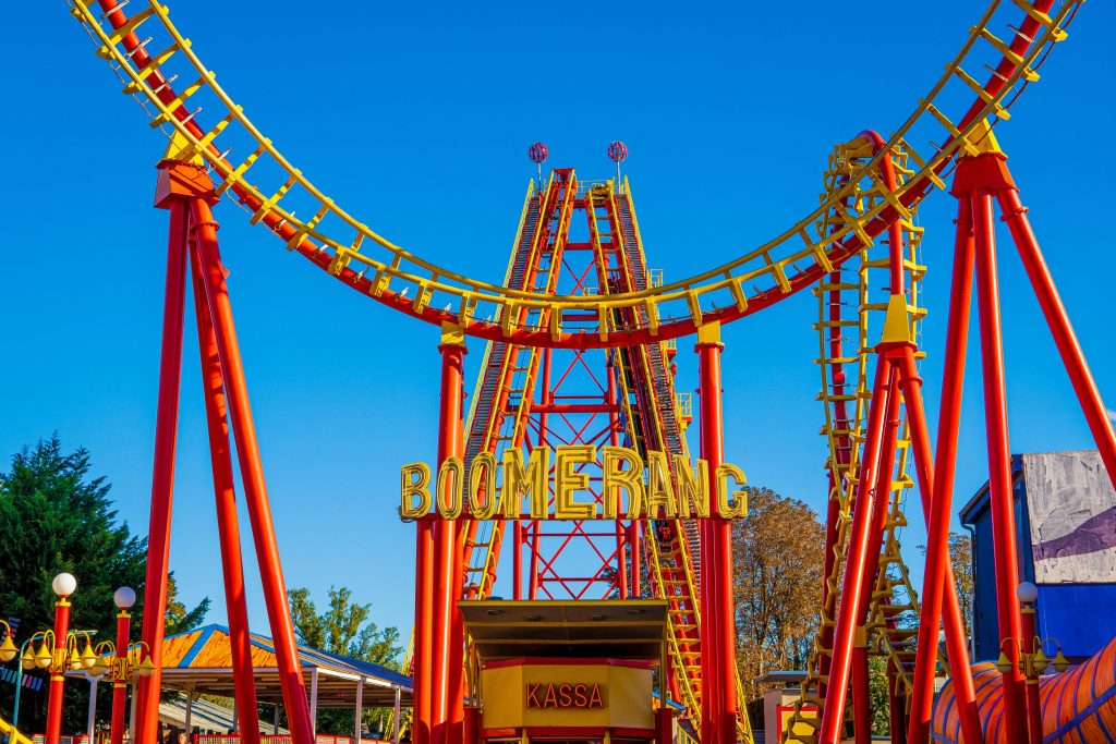 Bright red and yellow Boomerang roller coaster in Vienna, Austria amusement park. Montagnes russes Boomerang rouge vif et jaune dans un parc d'attractions de Vienne, en Autriche.