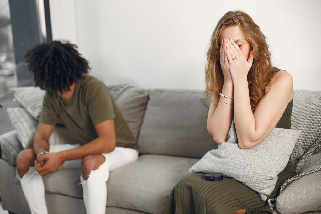 Couple en conflit émotionnel sur un canapé à l'intérieur avec un effet de profondeur de champ
