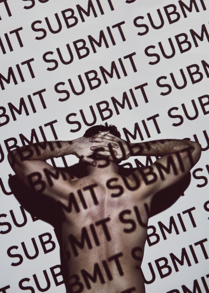 Artistique photographie du dos d'un homme avec un texte "SUBMIT" répété en superposition, les bras croisés derrière la nuque.
