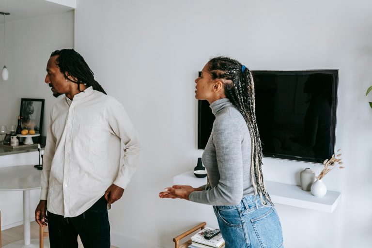 Emotional couple noir debout dans un appartement douillet en conflit pendant qu'ils passent du temps ensemble