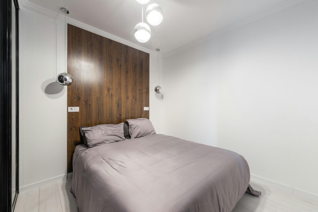 Contemporary bedroom avec un design épuré, des accents en bois et des luminaires suspendus.