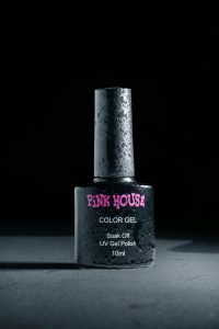 Gros plan sur un flacon de vernis à ongles en gel UV avec des gouttelettes d'eau, éclairage studio.