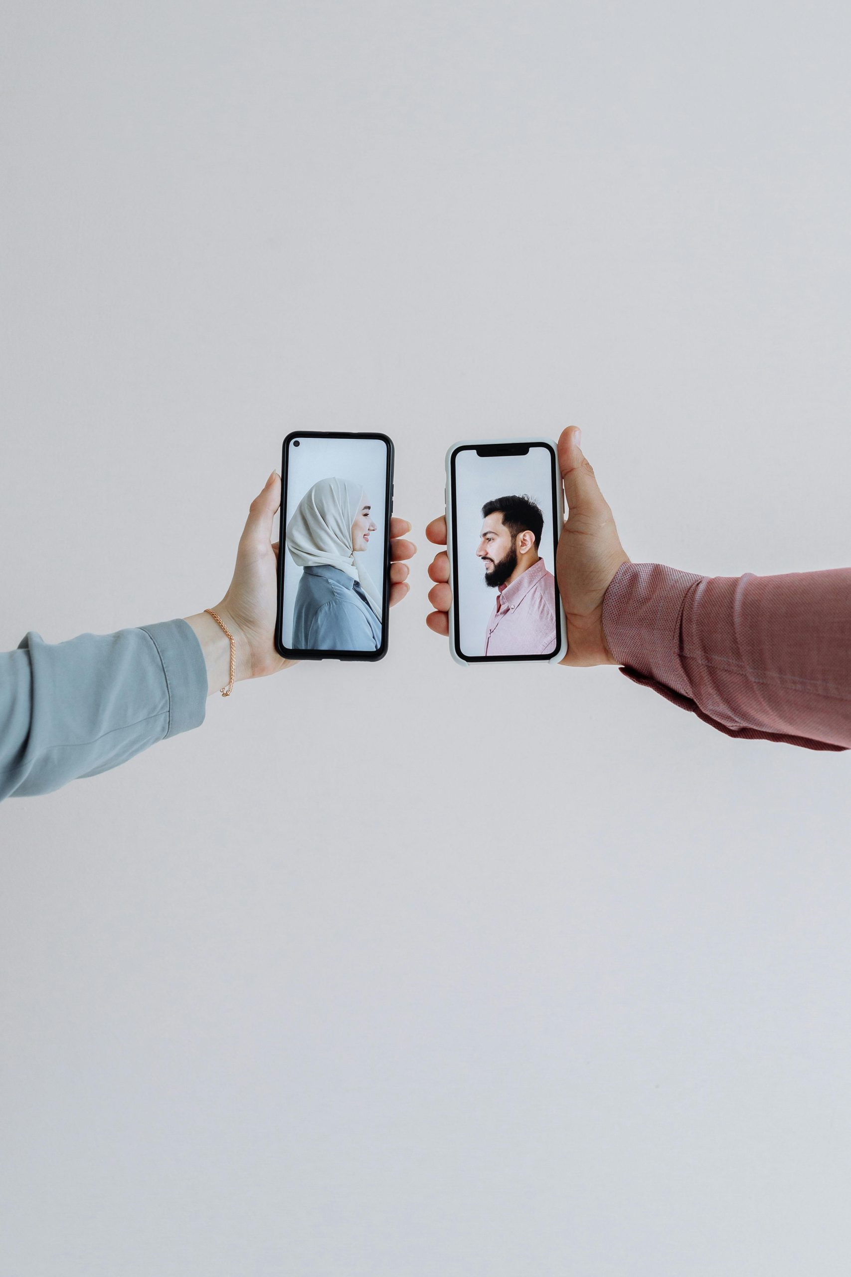 Two people holding smartphones with video call showing face-to-face communication. Deux personnes tenant des smartphones avec un appel vidéo montrant une communication face à face.