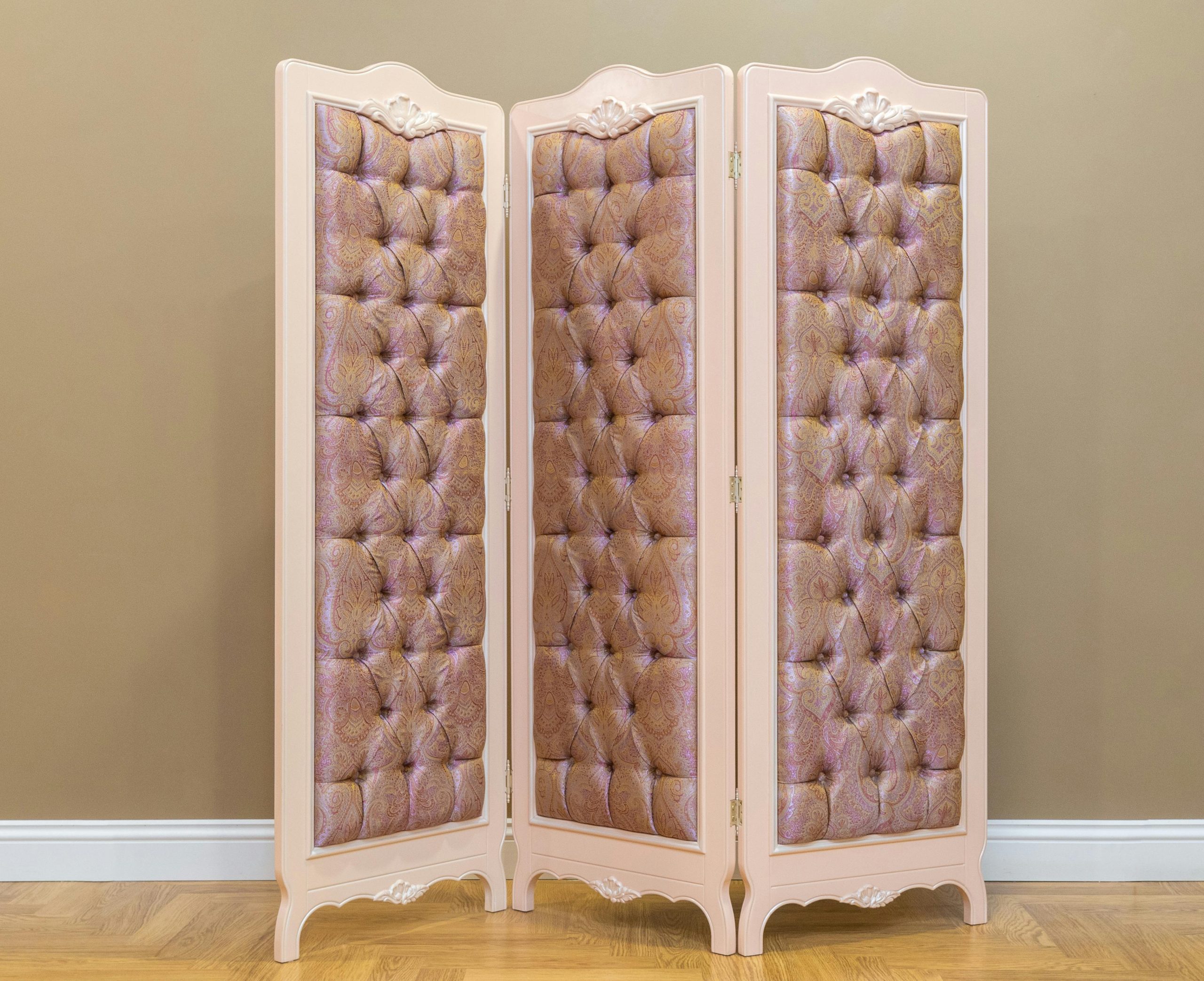 Élégant paravent rembourré dans un dressing classique avec parquet, ajoutant du style et de l'intimité.