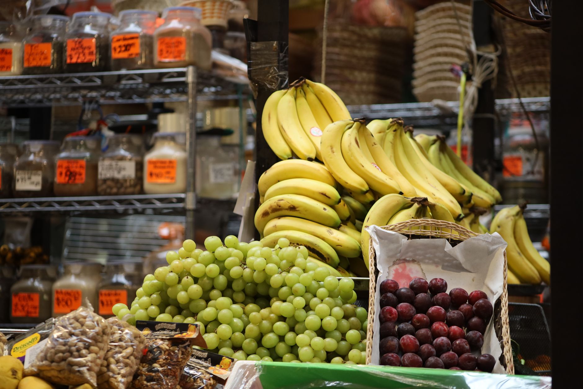Étal de marché avec bananes, raisins et prunes
