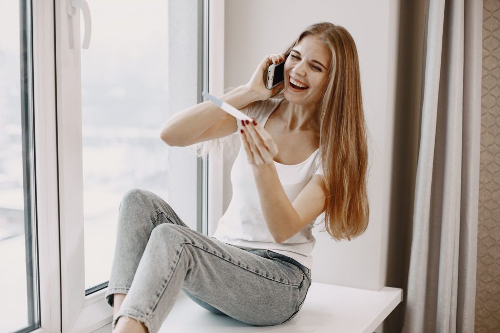 Femme heureuse tenant un test de grossesse positif