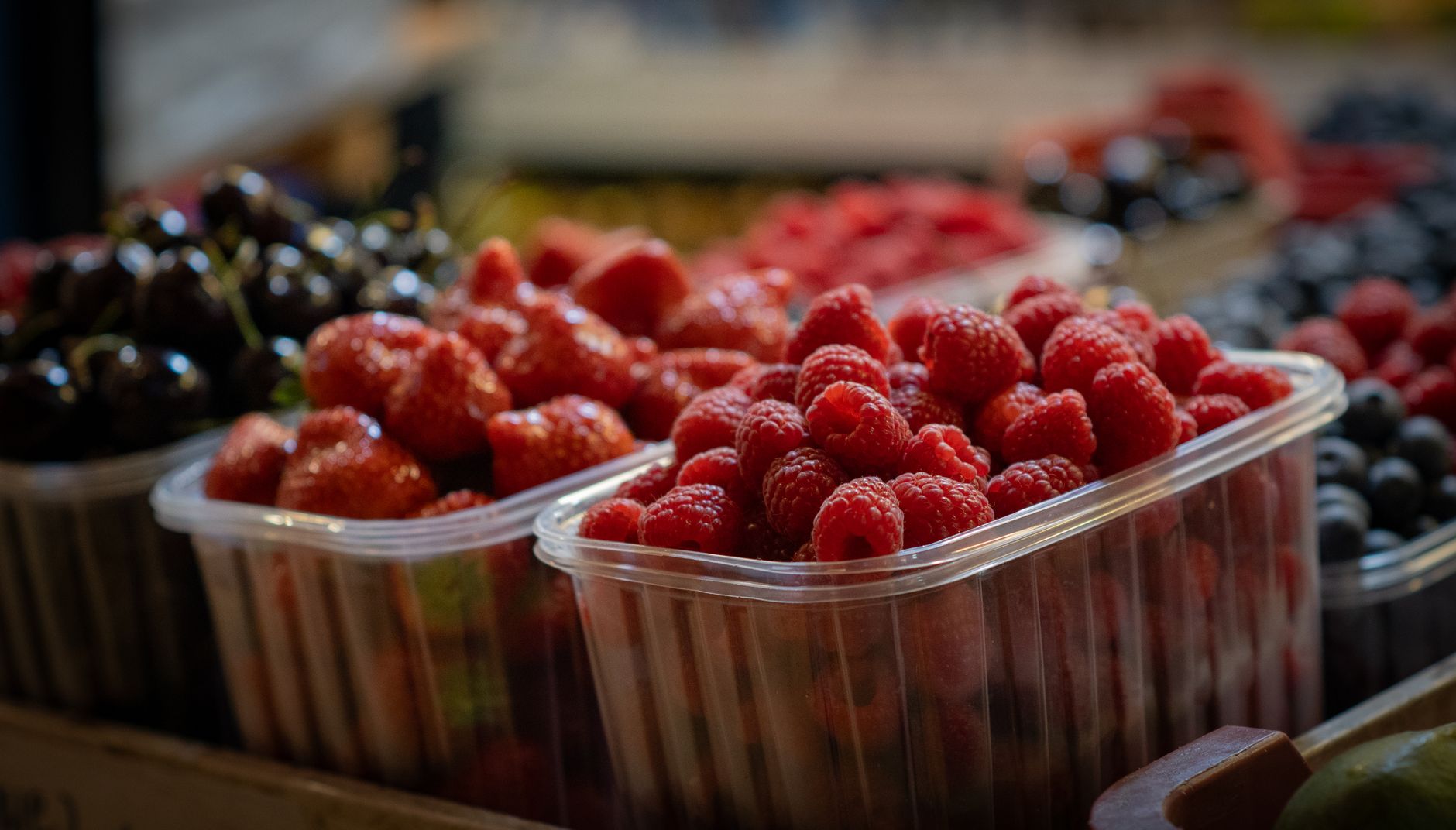 Framboises, fraises et cerises fraîches en barquette