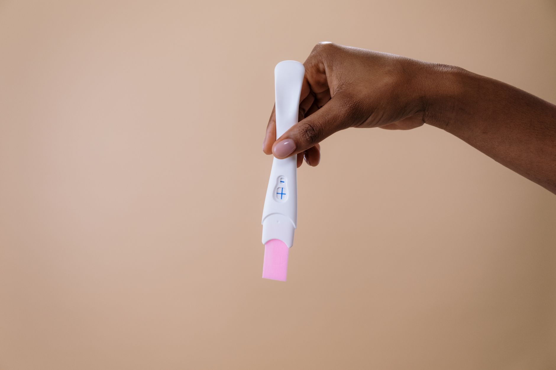 Mains tenant un test de grossesse de près
