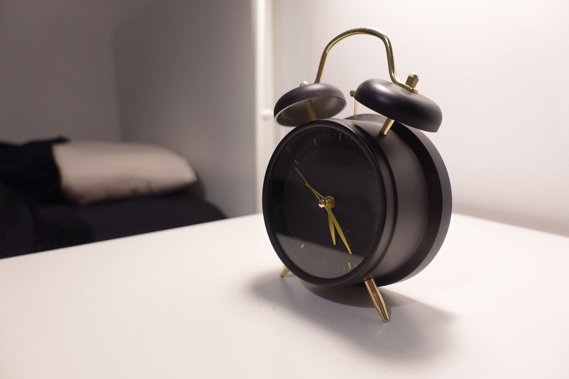 Réveil posé sur une table de nuit la nuit