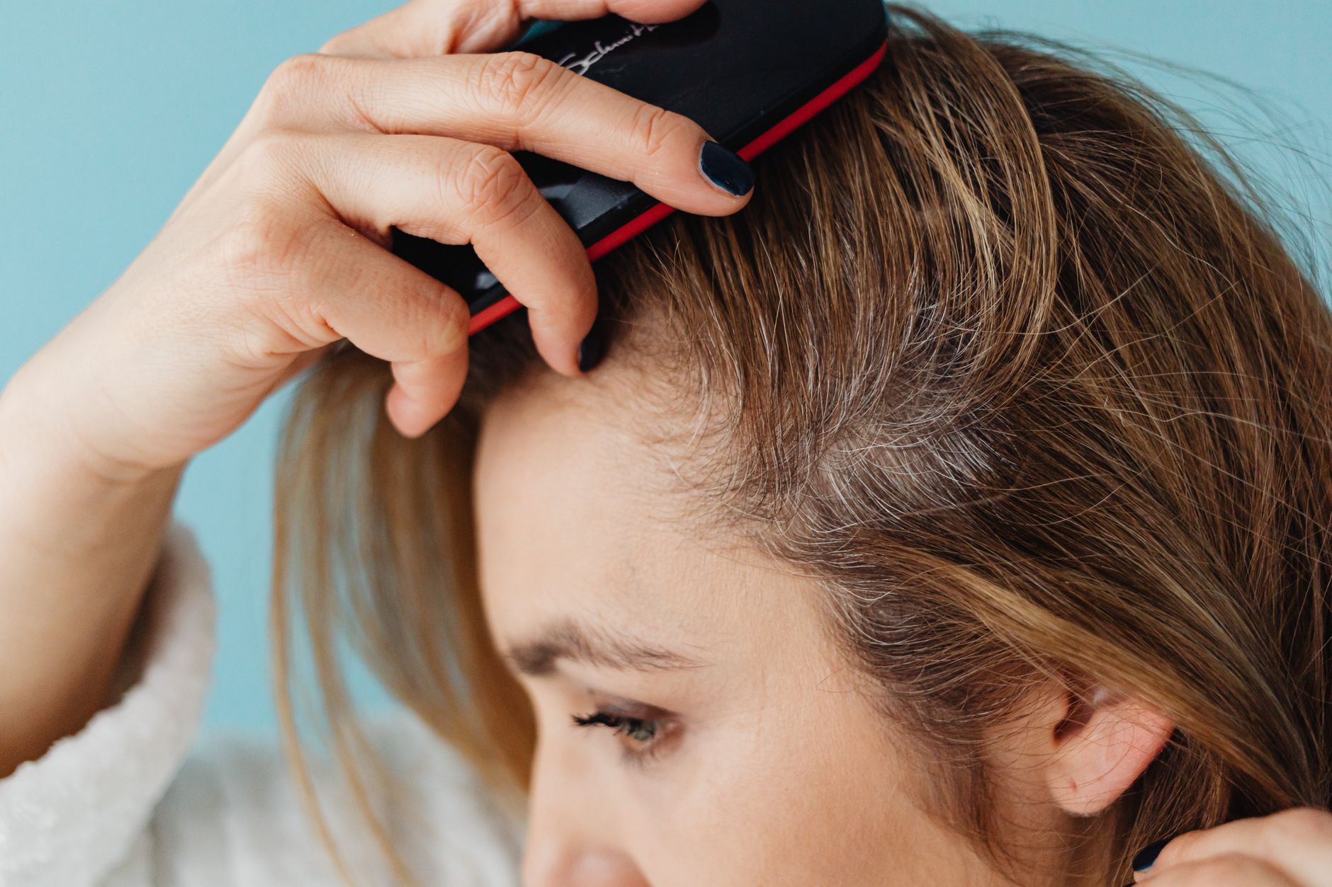 Femme qui brosse ses cheveux pour repartir le sebum