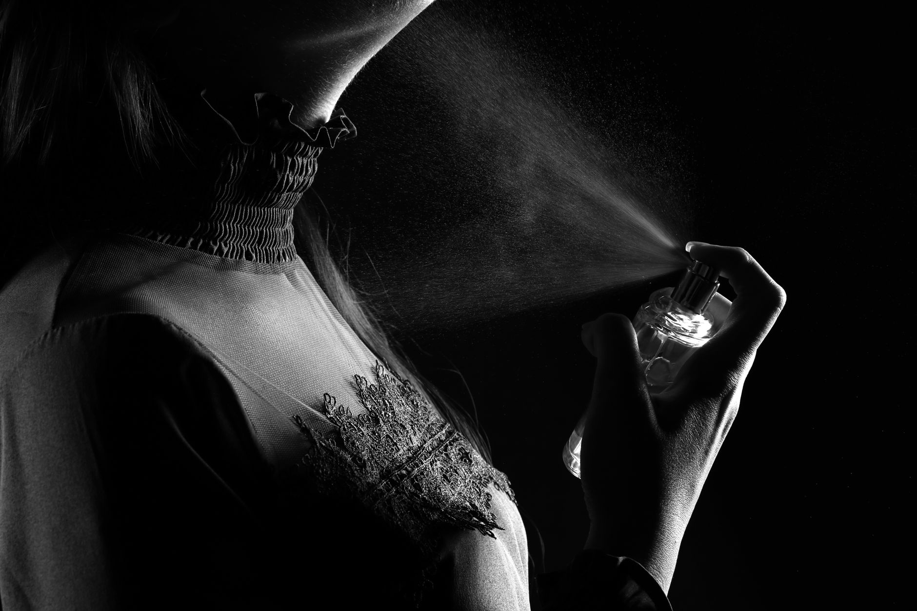 Femme qui vaporise du parfum